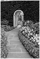 Arched entrance  leading to the Italian Garden. Butchart Gardens, Victoria, British Columbia, Canada (black and white)