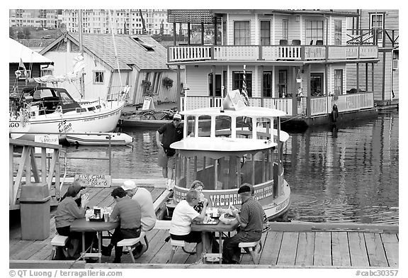 People eating fish and chips on deck,  Fisherman's wharf. Victoria, British Columbia, Canada