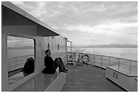 Passenger sitting on the deck of ferry. Vancouver Island, British Columbia, Canada ( black and white)