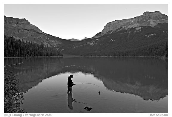 Woman fishing in Emerald Lake, sunset. Yoho National Park, Canadian Rockies, British Columbia, Canada (black and white)