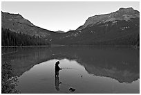 Woman fishing in Emerald Lake, sunset. Yoho National Park, Canadian Rockies, British Columbia, Canada (black and white)