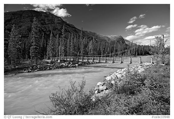 Suspension bridge spanning the Vermillion River. Kootenay National Park, Canadian Rockies, British Columbia, Canada (black and white)