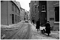 Residents pulling a sled with a child in a street, Quebec City. Quebec, Canada (black and white)