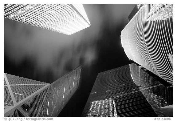 Looking up from plaza with Bank of China and Cheung Kong Center buildings by night. Hong-Kong, China (black and white)