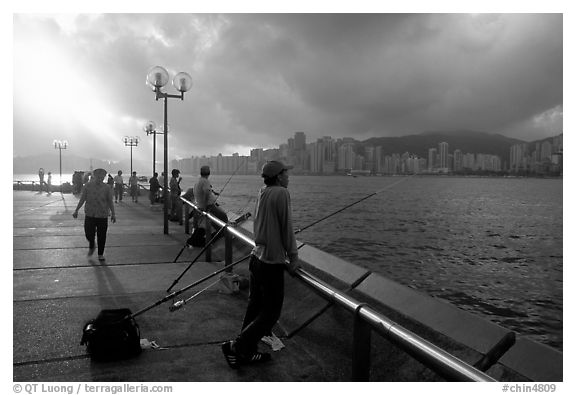 Fishing on the waterfront promenade, sunrise. Hong-Kong, China