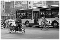 Tricyle, bicycles and bus on street. Beijing, China (black and white)