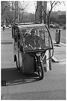 Enclosed three wheel motorcycle on street. Beijing, China (black and white)