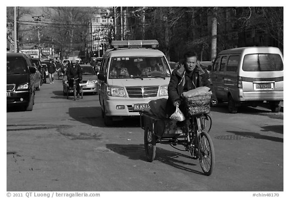 Tricycle and taxi on street. Beijing, China (black and white)