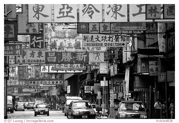 Taxicabs in a street filled up with signs in Chinese, Kowloon. Hong-Kong, China (black and white)