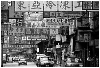 Taxicabs in a street filled up with signs in Chinese, Kowloon. Hong-Kong, China (black and white)