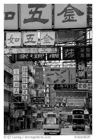 Busses in a street filled up with signs in Chinese, Kowloon. Hong-Kong, China (black and white)