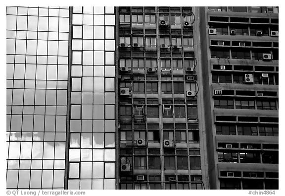 Glass building next to older buildings with air conditioners, Hong-Kong Island. Hong-Kong, China (black and white)