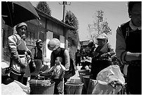 Women of Bai hill tribe offering incense for sale. Shaping, Yunnan, China ( black and white)