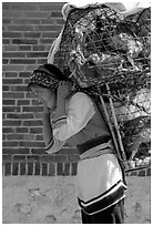 Woman carrying a load of chicken cages on forehead. Shaping, Yunnan, China ( black and white)