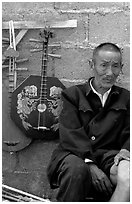 Man selling musical instruments. Shaping, Yunnan, China ( black and white)