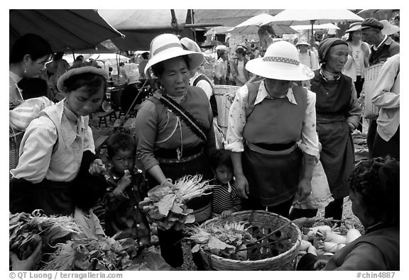 Bai women buying vegetables at the Monday market. Shaping, Yunnan, China (black and white)