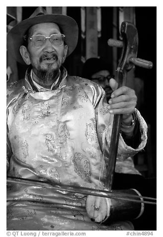 Elderly musician playing the traditional two-stringed Ehru. Baisha, Yunnan, China (black and white)