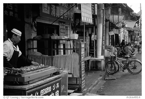 Muslim cook at restaurant storefront. Kunming, Yunnan, China (black and white)