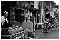 Muslim cook at restaurant storefront. Kunming, Yunnan, China ( black and white)