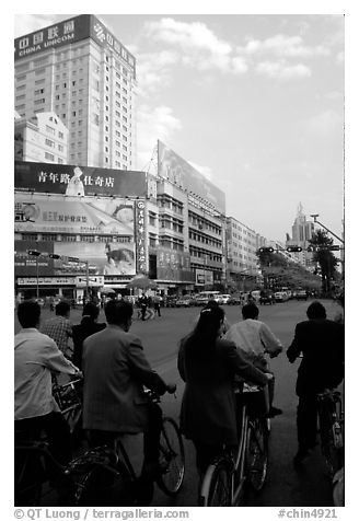 Bicyclists wait for the green light on a modern avenue. Kunming, Yunnan, China (black and white)