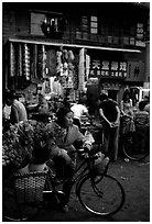 Flower peddler in an old alley. Kunming, Yunnan, China (black and white)