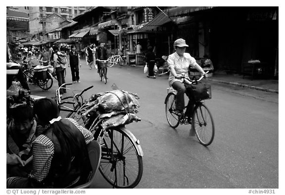 Woman on bicycle in an old backstreet. Kunming, Yunnan, China