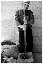 Spice vendor crushing red pepper. Dali, Yunnan, China (black and white)