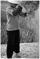 Woman sorts grain from hulls by pouring from a basket (winnowing). Dali, Yunnan, China ( black and white)