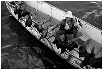 Fisherman talks to his cormorants at the end of fishing session. Dali, Yunnan, China (black and white)