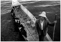 Cormorant Fisherman in a boat with his fishing birds. Dali, Yunnan, China (black and white)