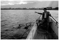 Cormorant Fisherman gives orders to his  fishing birds. Dali, Yunnan, China ( black and white)