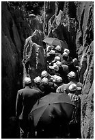 Crowds of Chinese tourists in a walkway among the limestone pillars. Shilin, Yunnan, China ( black and white)