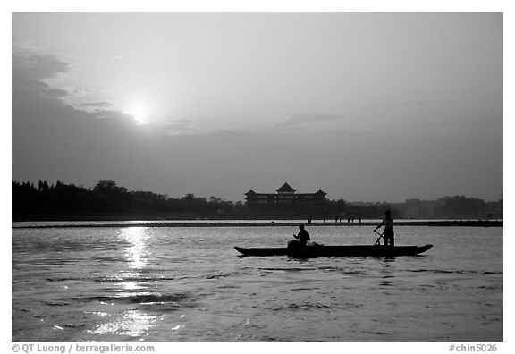 Fishermen at the confluence of the Dadu He and Min He rivers at sunset. Leshan, Sichuan, China