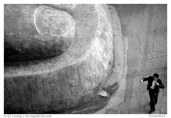 Man standing next to the toe of the Grand Buddha. Leshan, Sichuan, China (black and white)