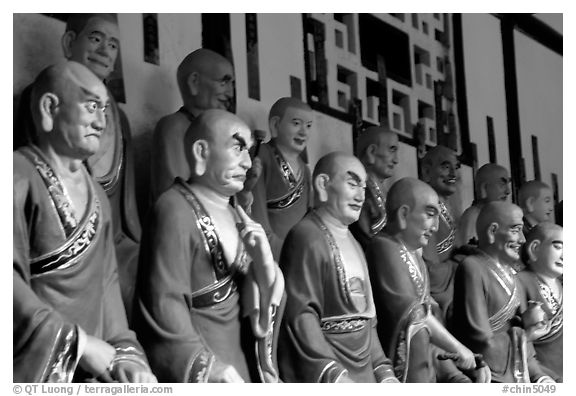 A variety of postures and expressions of some of the 1000 Terracotta arhat monks in Luohan Hall. Leshan, Sichuan, China (black and white)