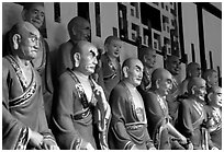 A variety of postures and expressions of some of the 1000 Terracotta arhat monks in Luohan Hall. Leshan, Sichuan, China (black and white)