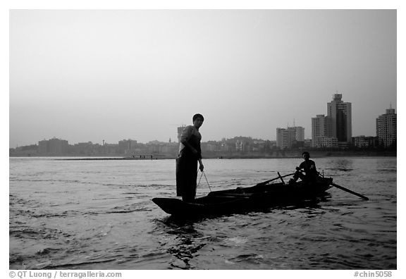 Fishermen at the confluence of the Dadu He and Min He rivers at sunset. Leshan, Sichuan, China (black and white)