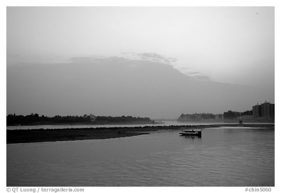 Boat at the confluence of the Dadu He and Min He rivers at sunset. Leshan, Sichuan, China