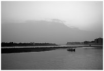Boat at the confluence of the Dadu He and Min He rivers at sunset. Leshan, Sichuan, China ( black and white)