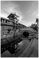 Kegong tower (memorial archway of imperial exam) reflected in canal, sunrise. Lijiang, Yunnan, China ( black and white)