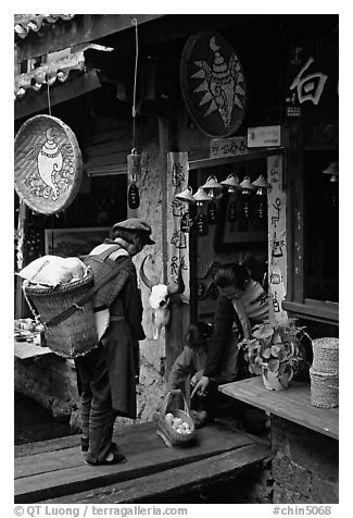 Naxi woman offers eggs for sale to local residents. Lijiang, Yunnan, China (black and white)