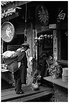 Naxi woman offers eggs for sale to local residents. Lijiang, Yunnan, China (black and white)