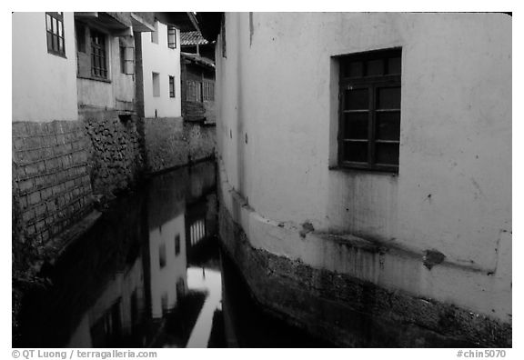 White walled houses surrounding a canal. Lijiang, Yunnan, China (black and white)