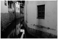 White walled houses surrounding a canal. Lijiang, Yunnan, China (black and white)