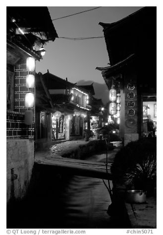 Streets, bridge, wooden houses, red lanterns and canal. Lijiang, Yunnan, China (black and white)