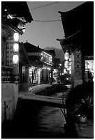 Streets, bridge, wooden houses, red lanterns and canal. Lijiang, Yunnan, China (black and white)