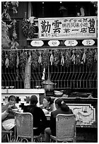 Women eat outside the Snack Food in Lijiang restaurant. Lijiang, Yunnan, China ( black and white)