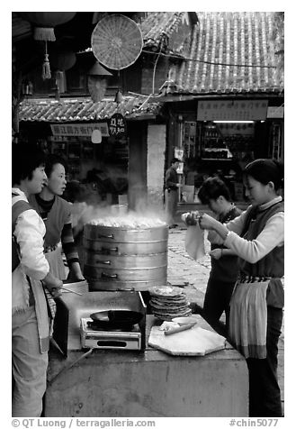 Naxi women selling dumplings and Naxi baba flatbread. Lijiang, Yunnan, China (black and white)