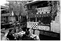 Women eat outside the Snack Food in Lijiang restaurant. Lijiang, Yunnan, China ( black and white)