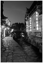 Cobblestone street and canal at night. Lijiang, Yunnan, China (black and white)